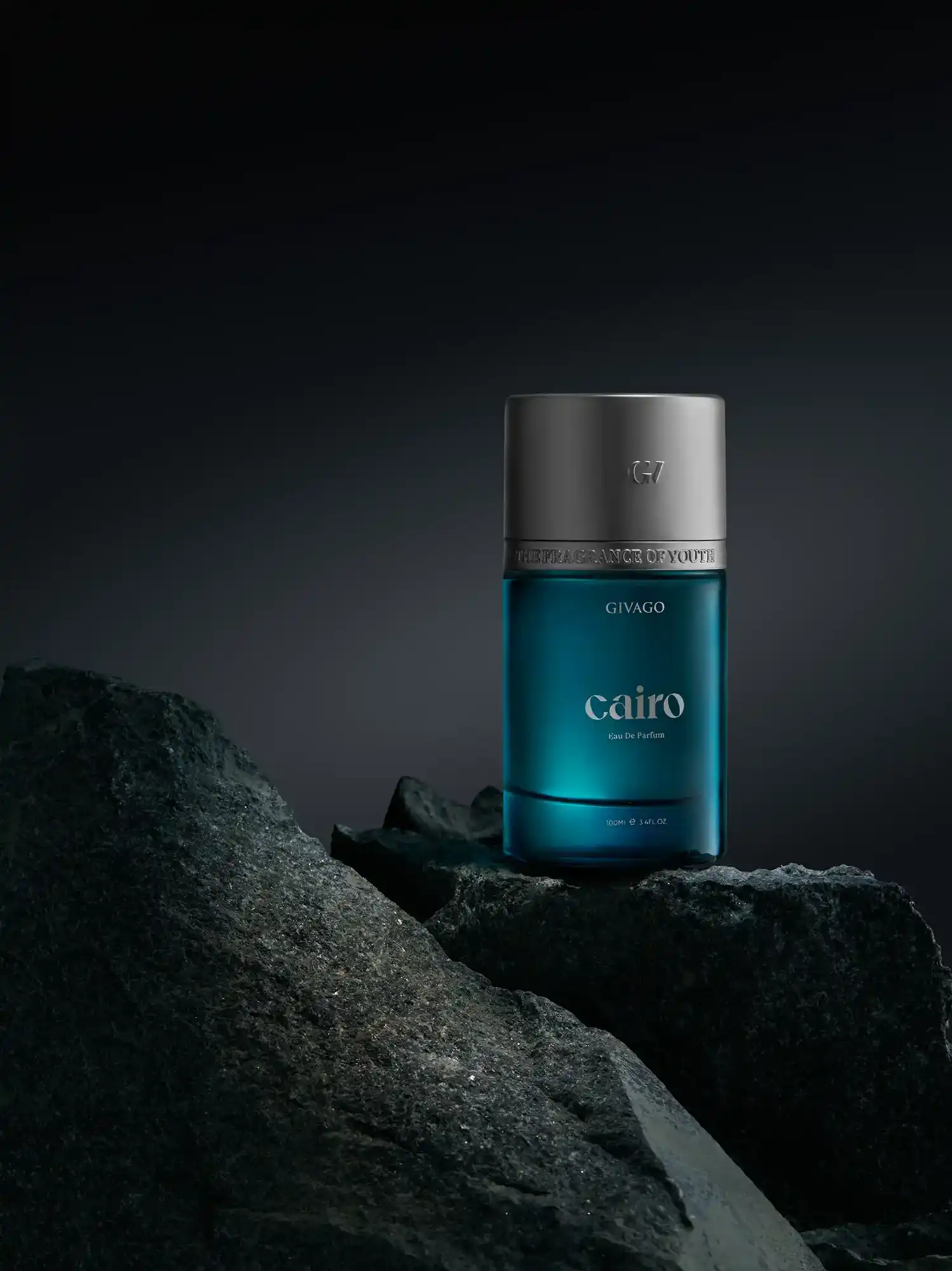 Givago Cairo perfume bottle in teal glass on dark rock against a blue-grey gradient