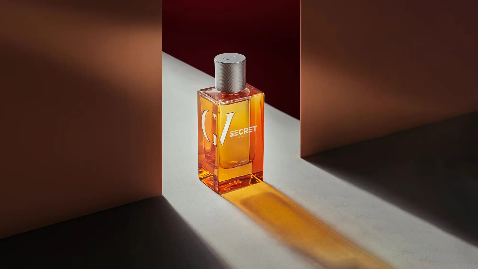 Givago Secret perfume photography © Mechanix Studios Givago Secret amber glass perfume bottle in a hard beam of light between terracotta walls